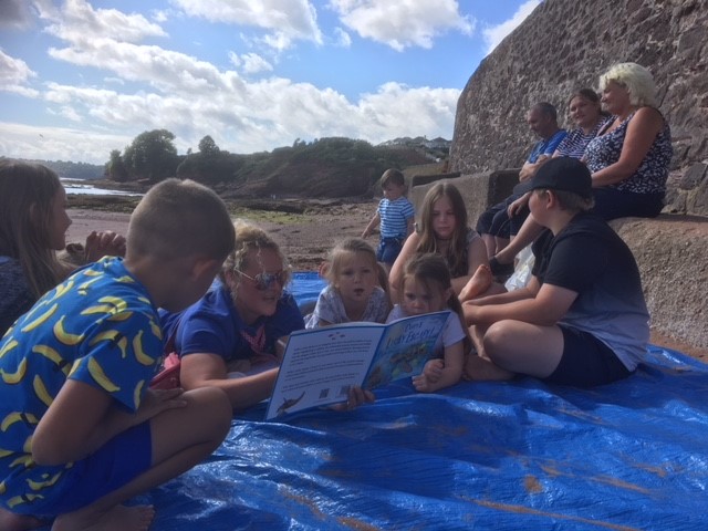 Children with their journey sticks they made during a Forest School session.  Children learning about the impact of plastic using a story book about a turtle eating plastic